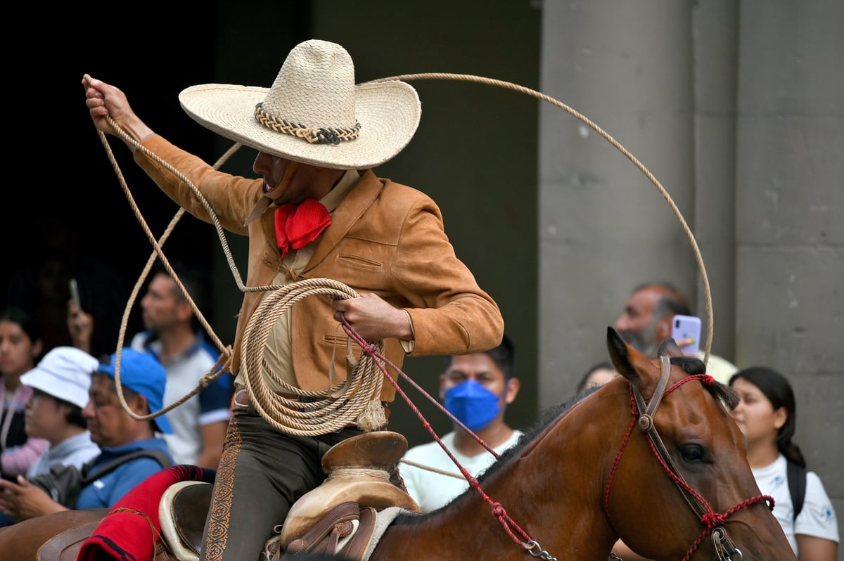 Charros montando a caballo en un desfile en Oaxaca